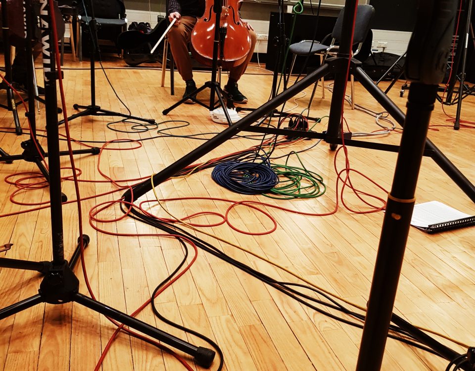 wiolonczela, kable i pulpity - drewniane instrumenty na drewnianej podłodze - przygotowania do nagrania krążka CD w Radiu Kraków
